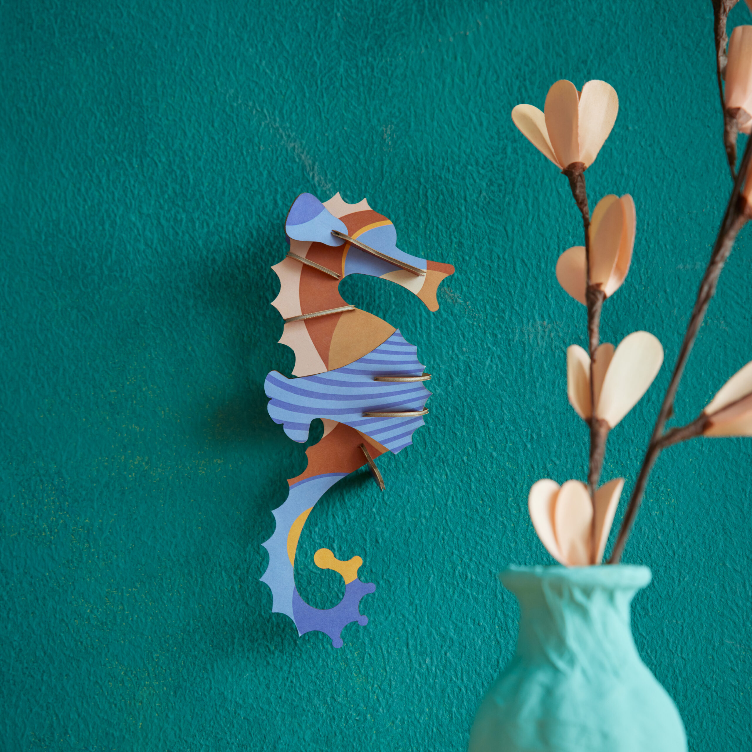 Blue Singlet Seahorse - Blaues Seepferdchen aus Papier in 3D als Wanddekoration von der Firma studio Roof auf grünem Hintergrund