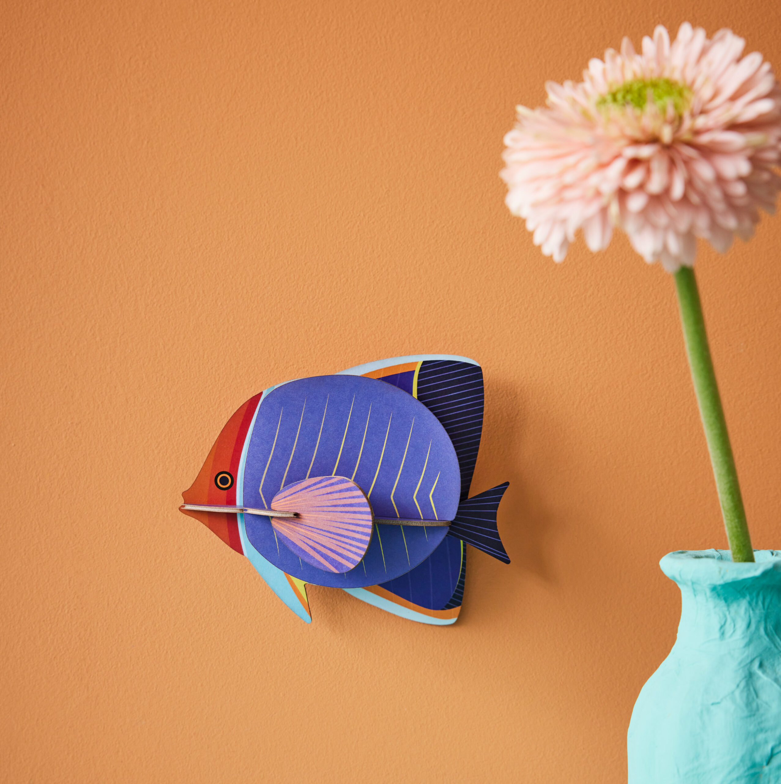 Butterfly_Fish - mehrfarbiger Faltenfisch aus Papier in 3D als Wanddekoration von der Firma studio Roof auf lachsfarbenem Hintergrund