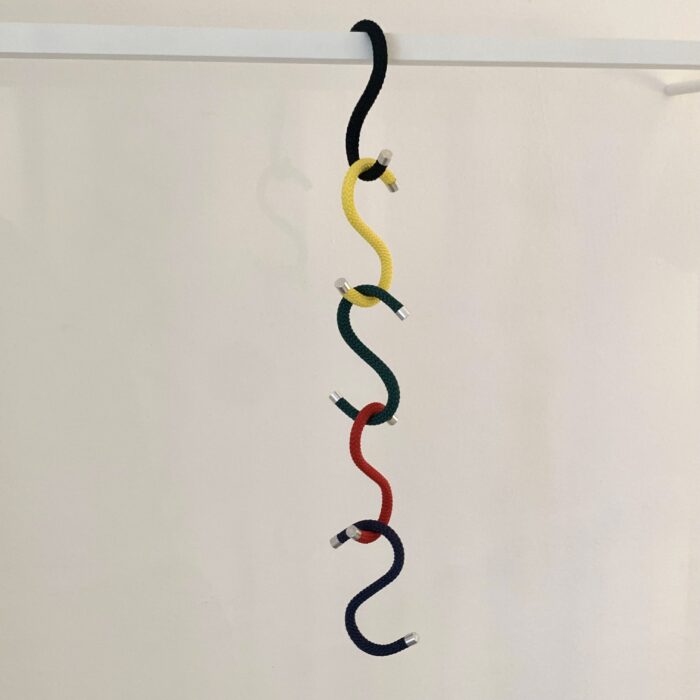 5 S-Haken (Rope Hook) ineinandergehängt in den Farben gelb, rot, grüne, schwarz und blau von der Firma Peppermint Products vor weißer Wand